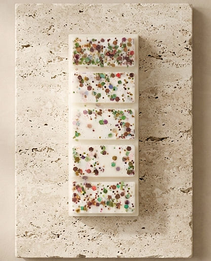 Sofia Dourvari Dubai Chocolate snap bar wax melt with vibrant multicolour confetti inclusions, displayed flat on a travertine stone