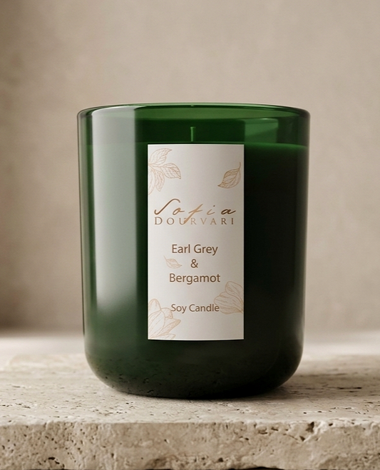 Sofia Dourvari Earl Grey & Bergamot heart-shaped coconut wax melts with green and gold shimmer swirl, arranged in a circle on a travertine tile